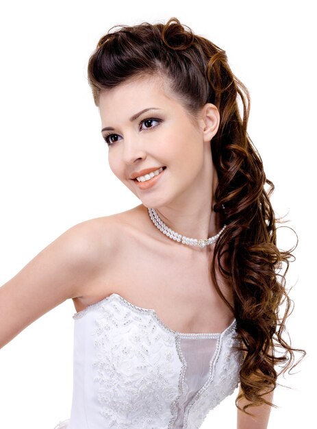 モダンな結婚式のヘアスタイルの長い巻き毛を持つ美しい若い笑顔花嫁