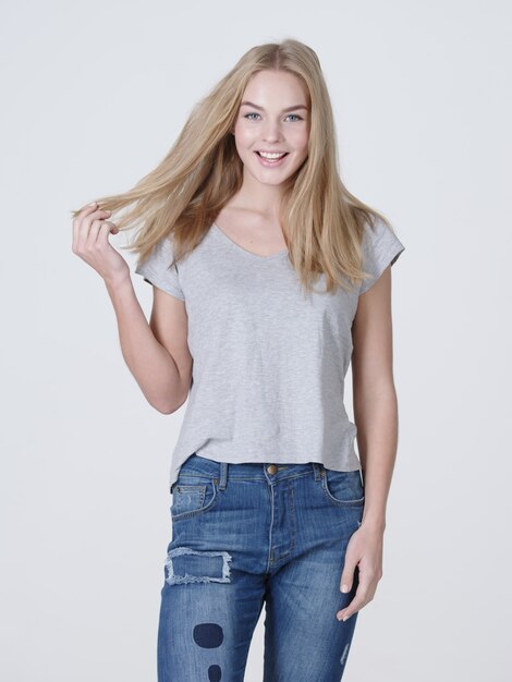 Beautiful young smiling caucasian woman with long blond hair posing  on white background.