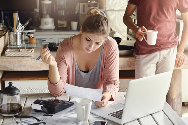 Beautiful young wife planning domestic budget, cutting off family expenses