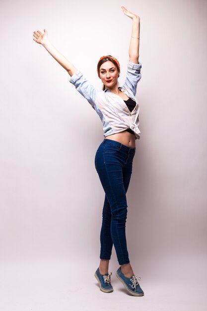 Beautiful young woman in casual wear raising arm over white