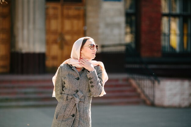 Beautiful young woman in a coat with a bag posing