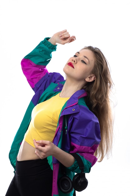 Beautiful young woman in colorful jacket and holding headphones