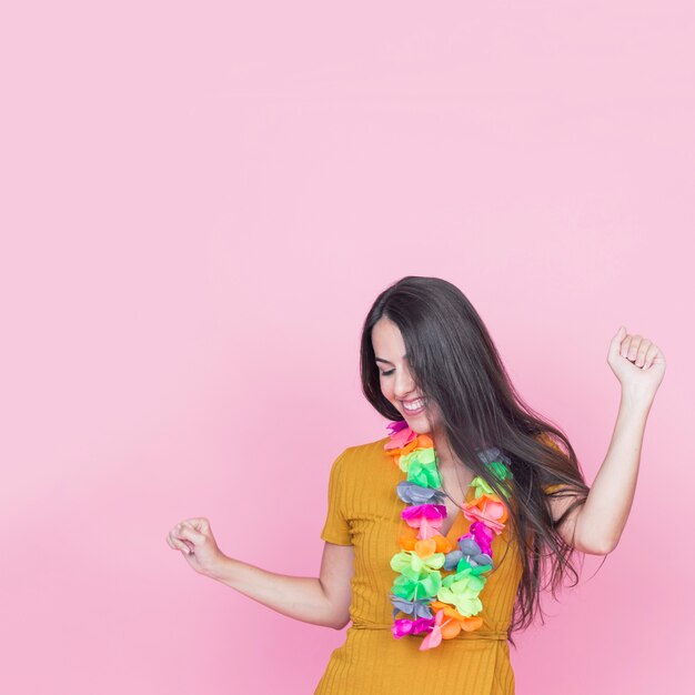 Beautiful young woman dancing on pink background