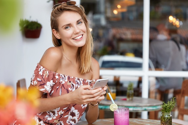 Beautiful young woman in dress in cafe