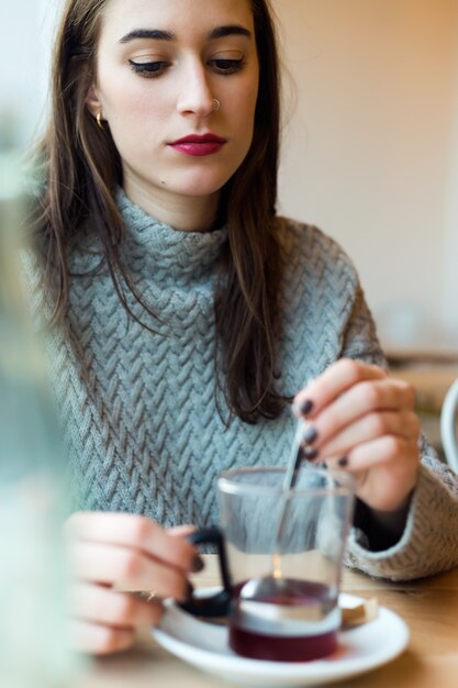 Beautiful young woman drinking tea in a coffee shop.