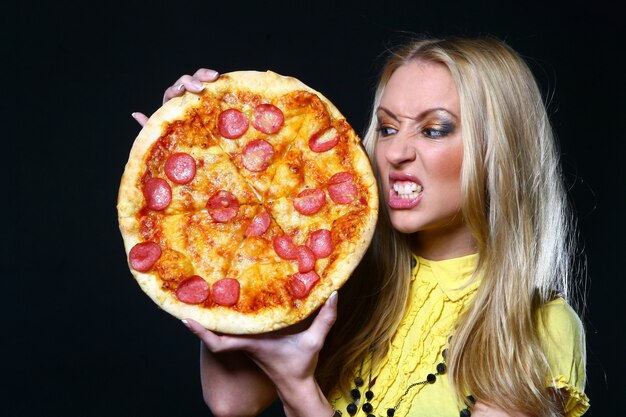 Beautiful young woman eating pizza