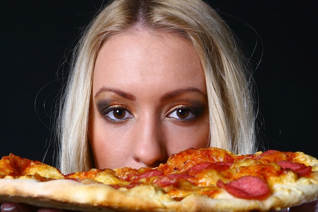 Free photo beautiful young woman eating pizza