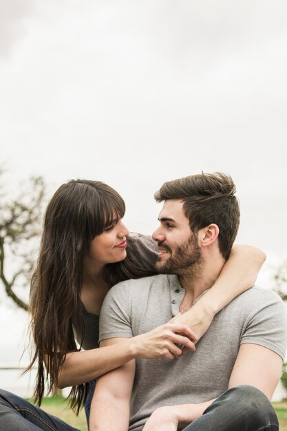 Beautiful young woman embracing her boyfriend looking at each other