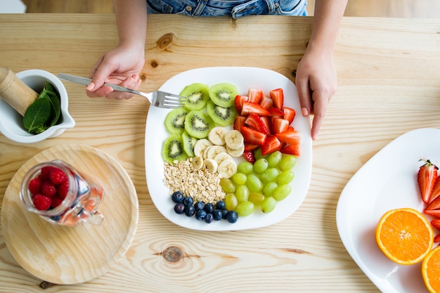 美しい若い女性は家で朝食を楽しんでいます。