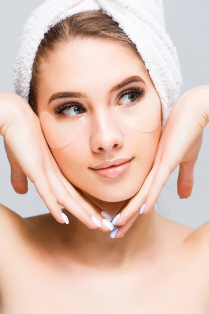 Beautiful young woman face with white towel on her head