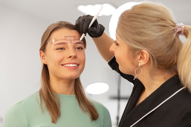 Free photo beautiful young woman going through a microblading treatment