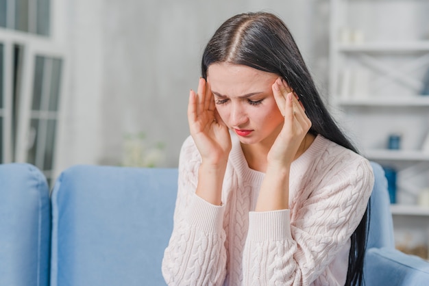 Free photo beautiful young woman having headache