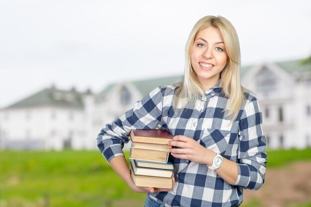 Beautiful young woman holding books