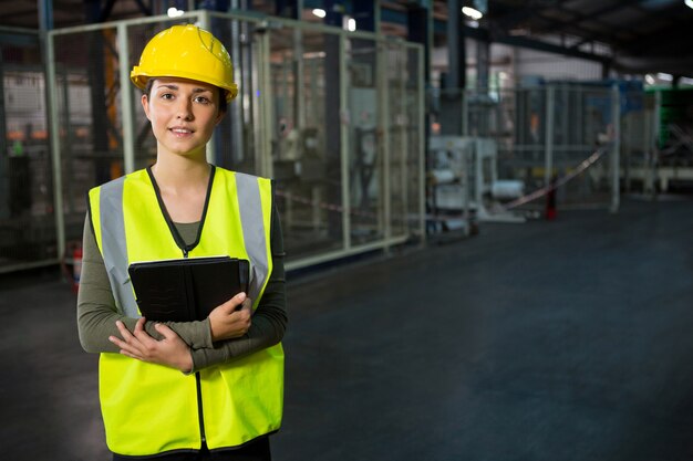 Beautiful young woman holding digital tablet in warehouse