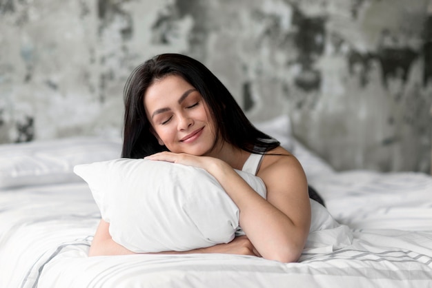 Beautiful young woman holding pillow