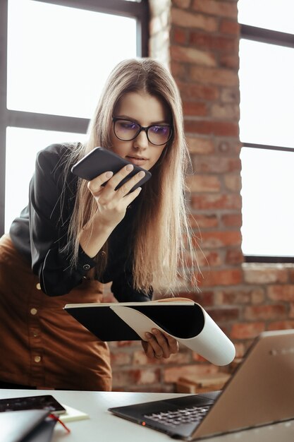 Beautiful young woman in the home office. Working from home. Teleworking concept