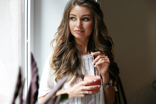 A beautiful young woman is posing in a cafe