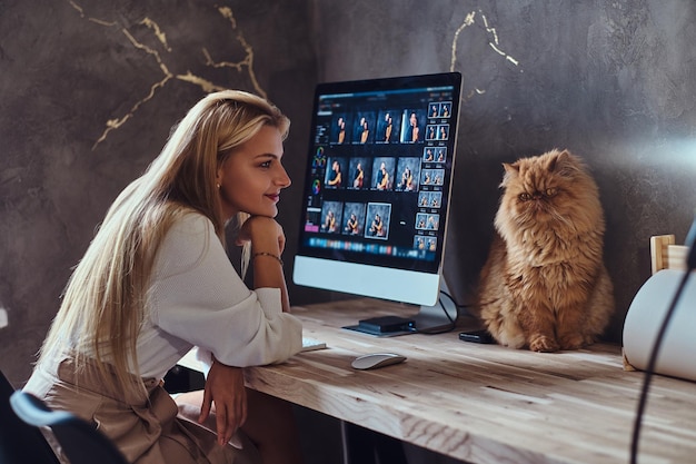 Beautiful young woman is sitting next to the table while her cat is sitting on the table.