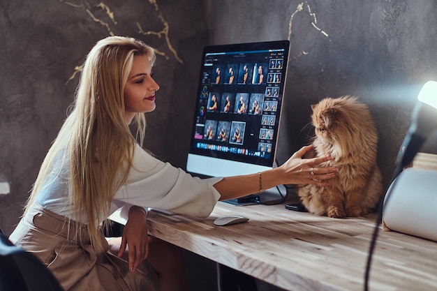 Beautiful young woman is sitting next to the table while her cat is sitting on the table.