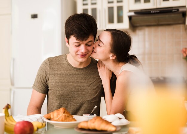 Beautiful young woman kissing her boyfriend