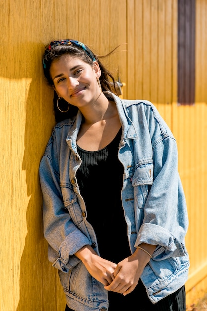 Beautiful young woman leaning on wooden wall