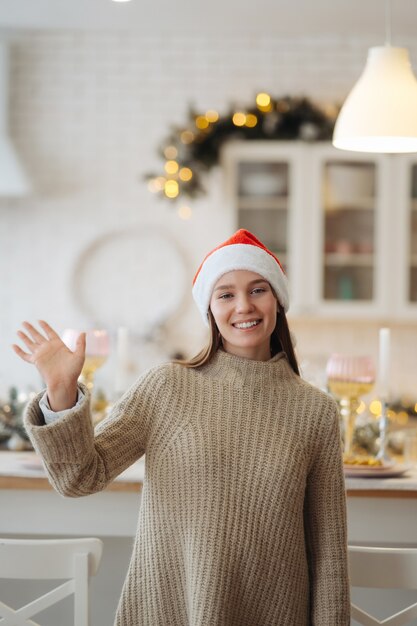 Beautiful young woman looking at the camera in home. Christmas celebration