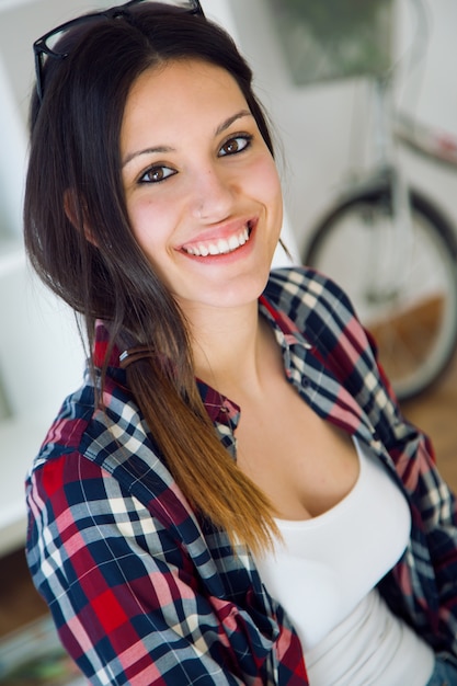 Beautiful young woman looking at camera at home.