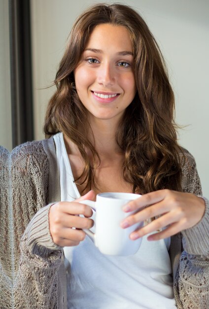 Beautiful young woman looking at camera at home.