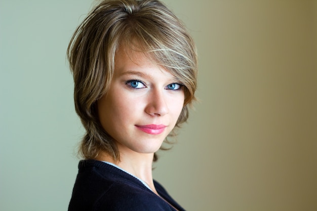 Beautiful young woman looking at camera at home.