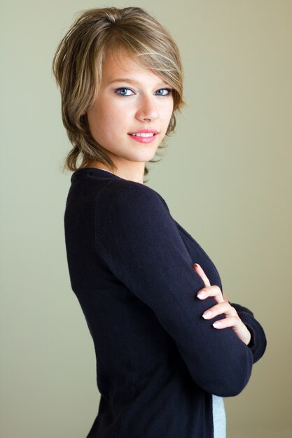 Beautiful young woman looking at camera at home.