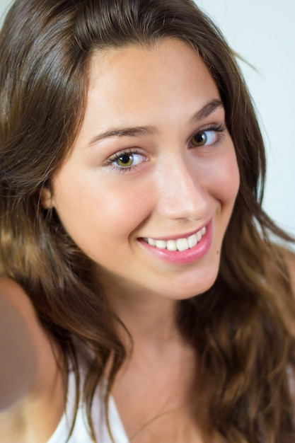 Beautiful young woman looking at camera at home.