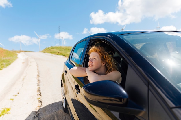 Beautiful young woman looking out car window