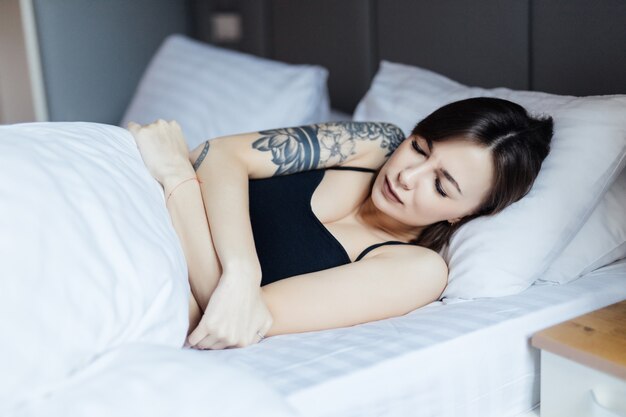 Beautiful Young woman lying in bed doesn't want to wake up