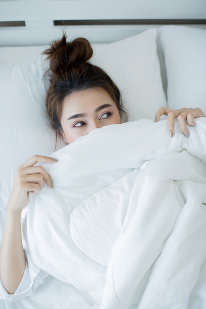 Beautiful young woman lying down in the bed and sleeping.