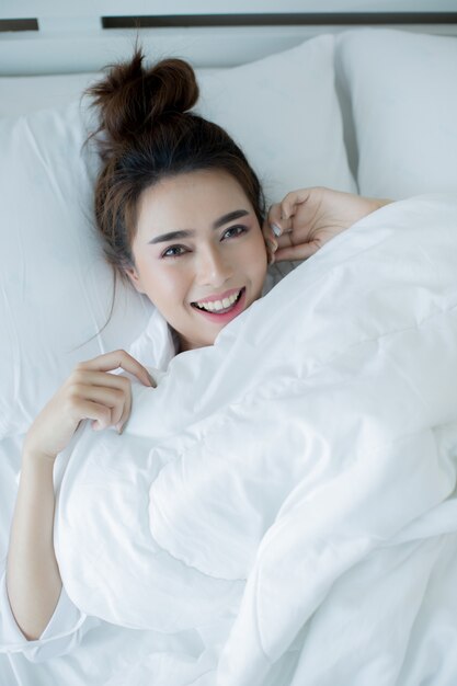 Beautiful young woman lying down in the bed and sleeping.