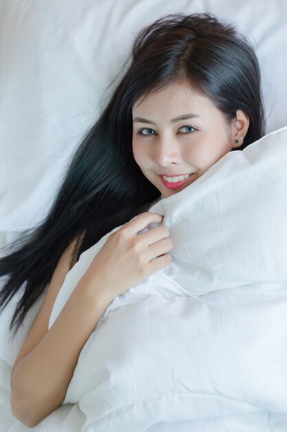 Beautiful young woman lying down in the bed.