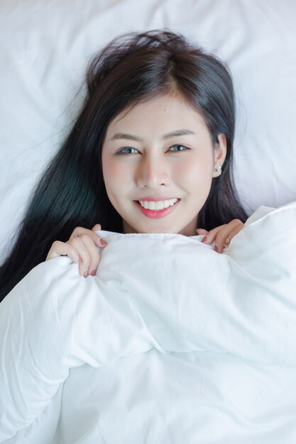 Beautiful young woman lying down in the bed.