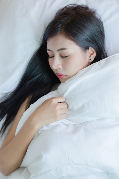 無料写真 美しい若い女性はベッドに横になって寝ています。