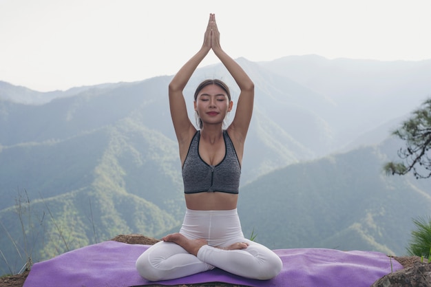 Бесплатное фото Красивая молодая женщина, медитируя и упражнения поверх него.