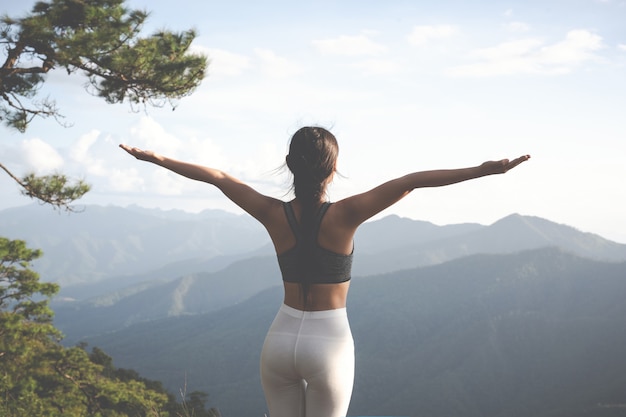 Beautiful young woman meditating and exercising on top of him.