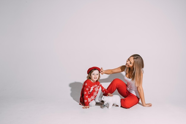 Beautiful young woman patting cute child on her head