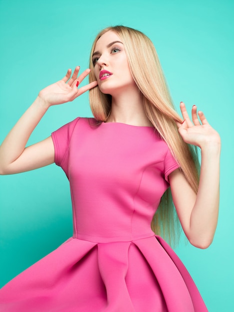 핑크 미니 드레스 포즈에서 아름 다운 젊은 여자