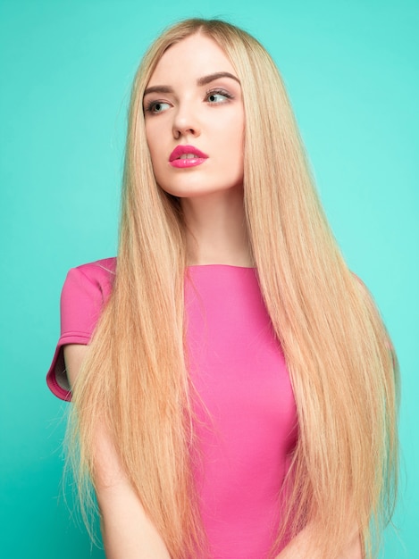 The beautiful young woman in pink mini dress posing 