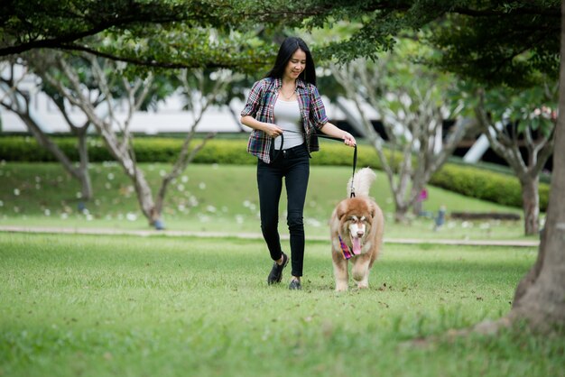 Красивая молодая женщина, играя со своей маленькой собакой в парке на открытом воздухе. Образ жизни портрет.