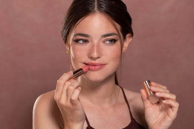 Портрет красивой молодой женщины с продуктом макияжа