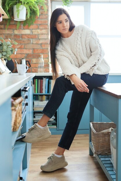 Beautiful young woman posing in the kitchen