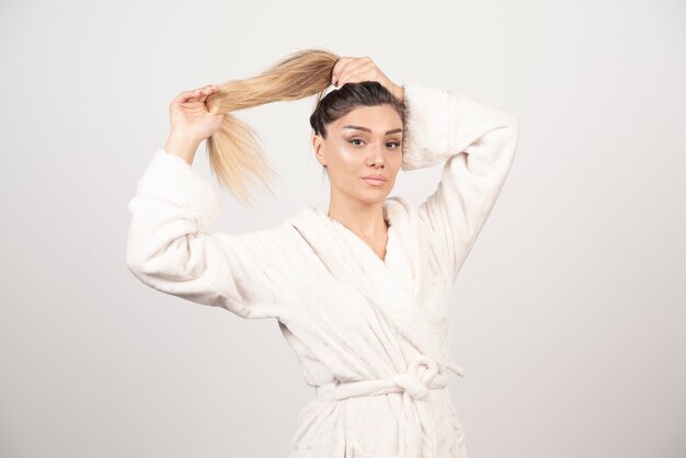 Beautiful young woman posing in a robe .