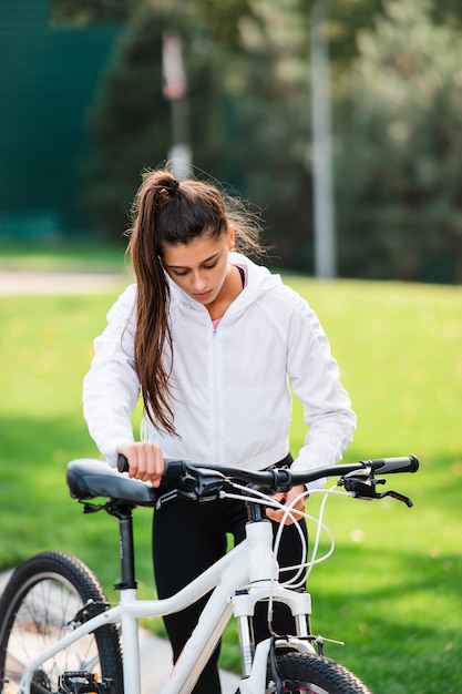 흰색 자전거에 포즈를 취하는 아름 다운 젊은 여자