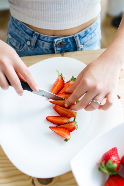 Beautiful young woman preparing breakfast at home.