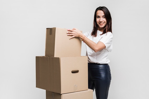 Beautiful young woman preparing moving boxes